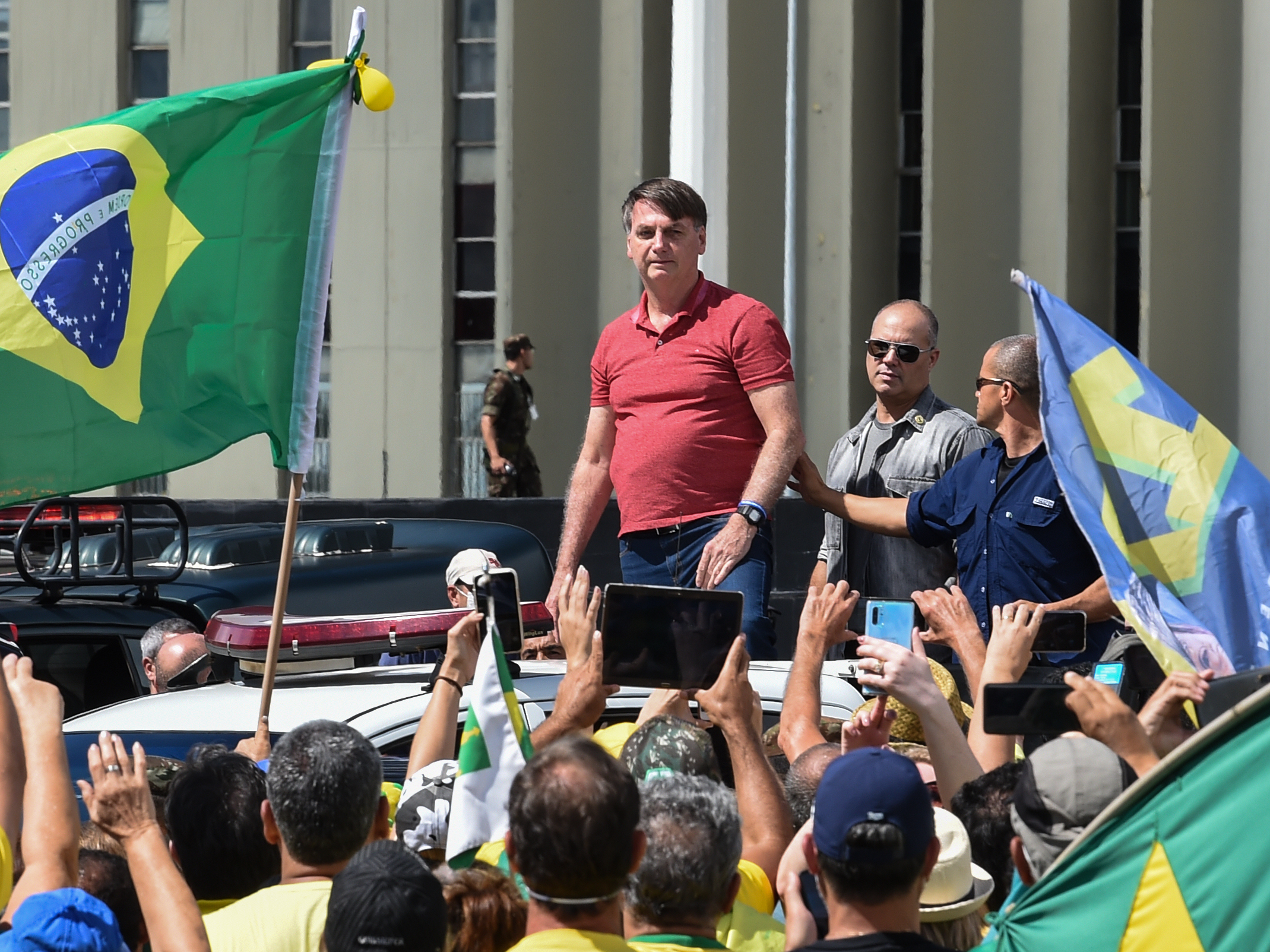 caption: Brazilian President Jair Bolsonaro prepares to speak to supporters protesting against quarantine and social distancing measures to combat the new coronavirus outbreak in Brasilia on Sunday.