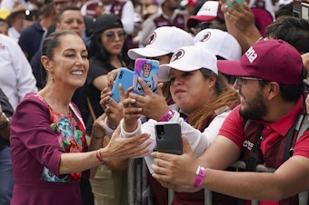 caption: Presidential candidate Claudia Sheinbaum greets supporters upon her arrival to her opening campaign rally at the Zocalo in Mexico City, Friday, March 1, 2024.