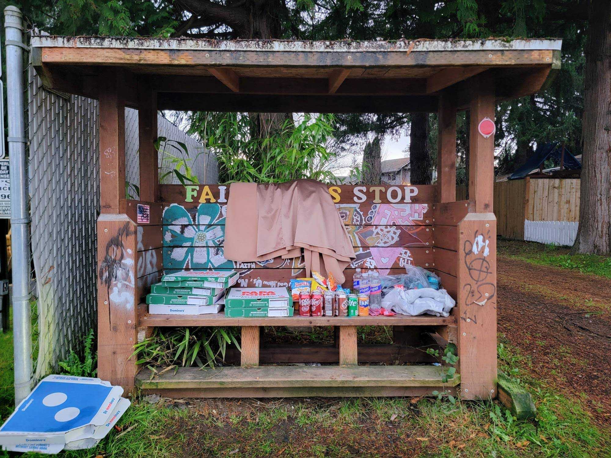 caption: A community bulletin board in the south King County community of Pacific has been converted into a makeshift food pantry for residents and first responders after the White River flooded this week. 