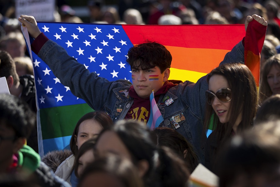 caption: Nicolas Velasquez, 17, holds a rainbow flag during a walkout to protest the departure of two LGBT educators on Tuesday, February 18, 2020, at Kennedy Catholic High School in Burien. "I don't think that it's okay that this is happening now," Velasquez said. "I want to be the change that I want to see." 