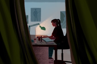 A young student attends online school from her bedroom.