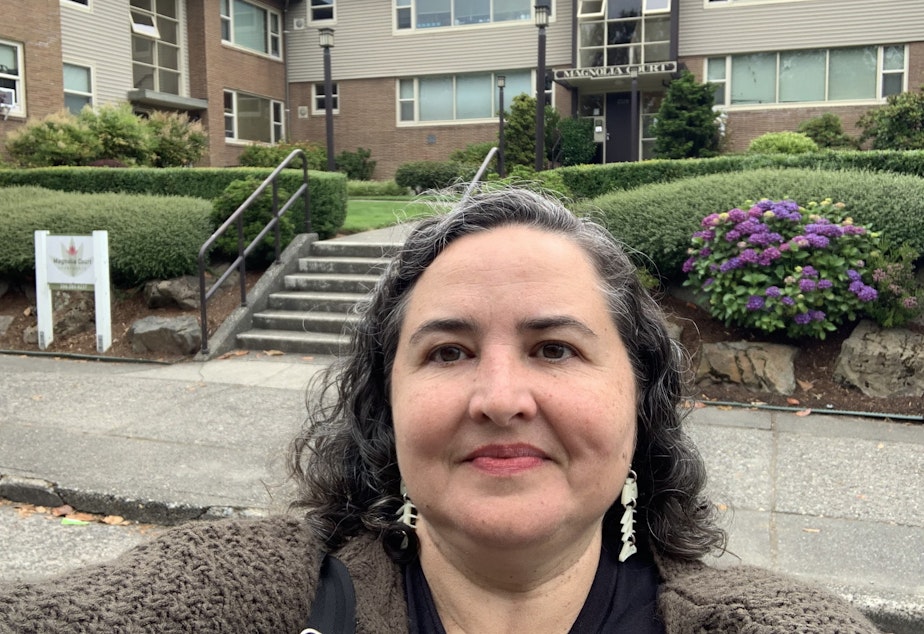 caption: Laura Loe stops for a selfie in front of a 1940s 24-unit Courtyard apartment building in Magnolia. This is historic "missing middle" housing