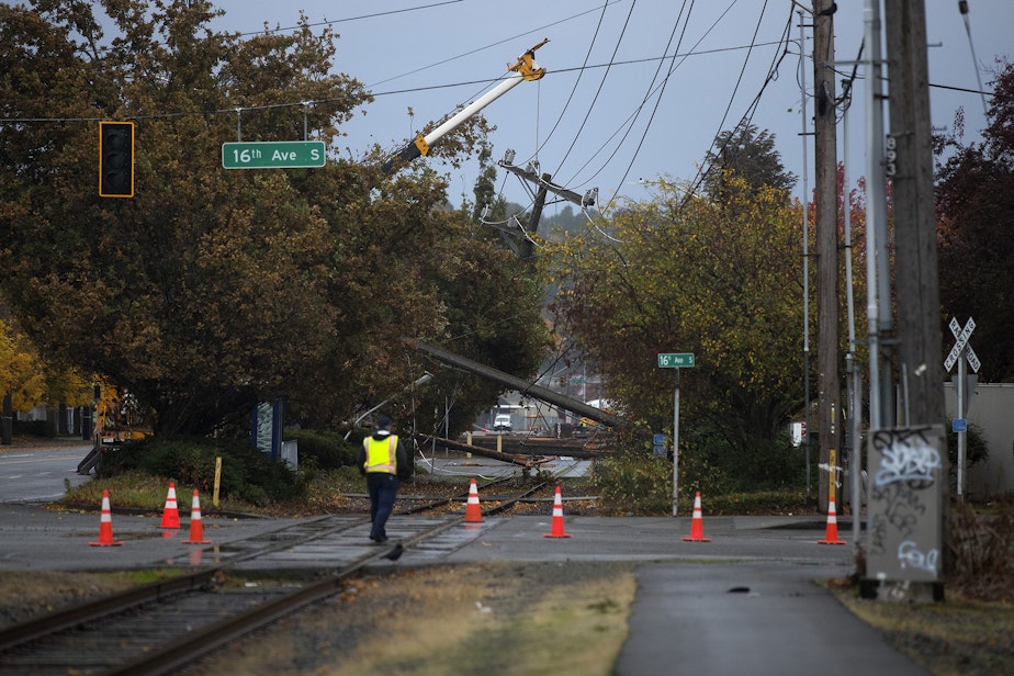 caption: Downed power lines are shown at the intersection of 16th Avenue South and East Marginal Way South after heavy winds on Monday October 25, 2021, in Seattle. 