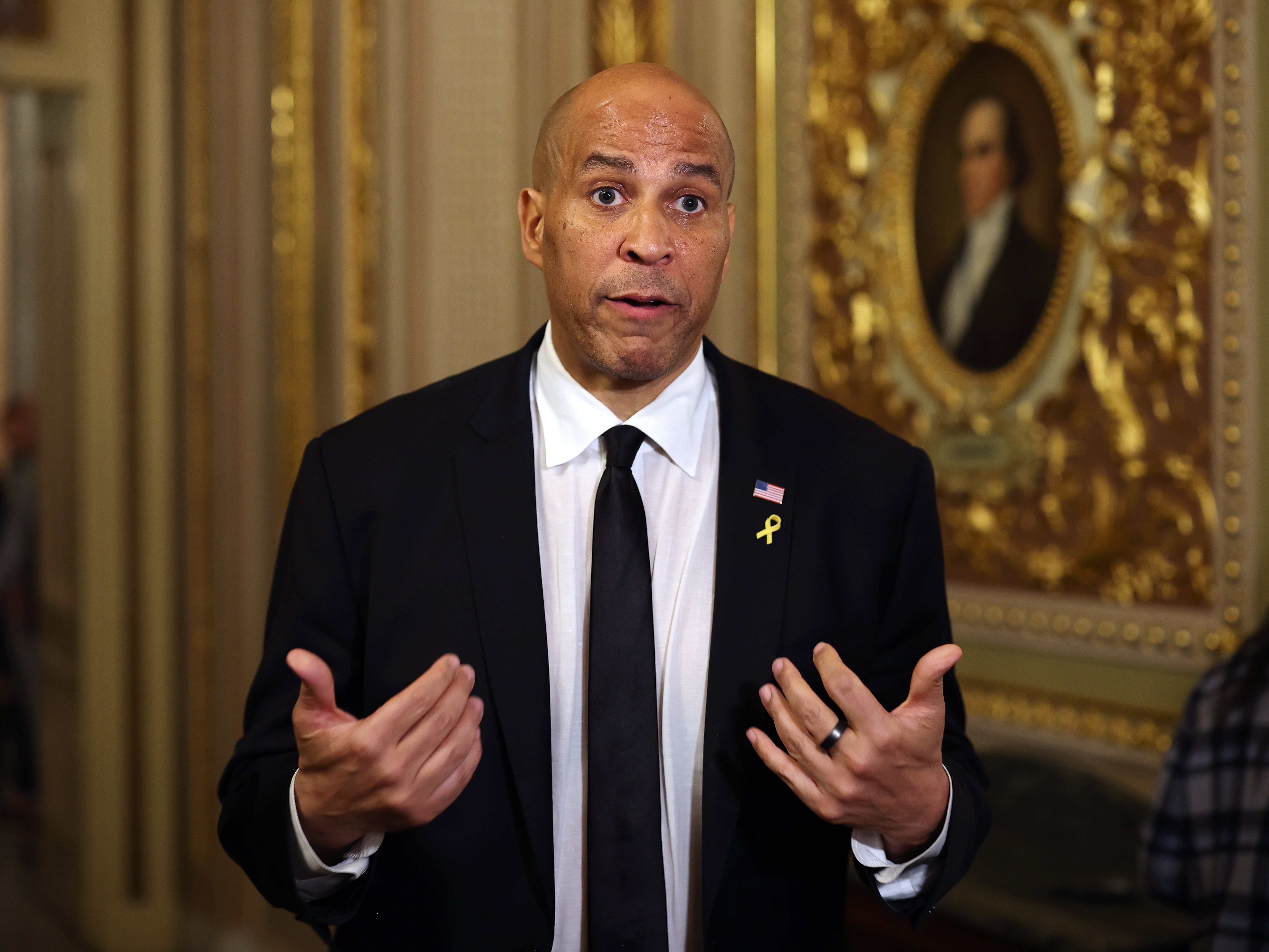 caption: Sen. Cory Booker speaks to reporters as he leaves the Senate chamber after delivering a record-setting floor speech on Tuesday. Contrary to popular belief, the speech was not technically a filibuster.
