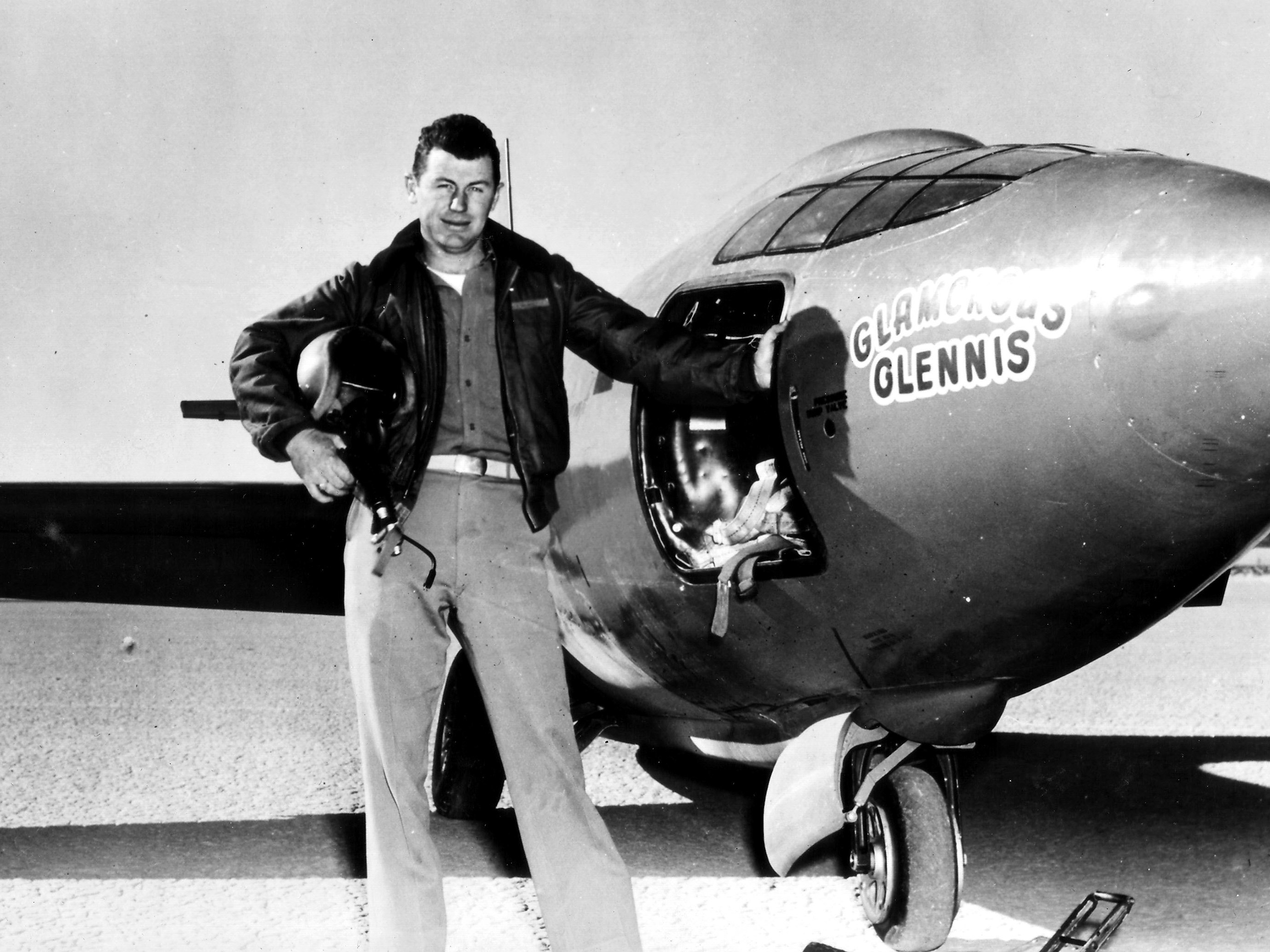 caption: Chuck Yeager, standing next to the "Glamorous Glennis," the Bell X-1 experimental plane in which he first broke the sound barrier.