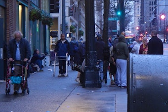 caption: Crowds of homeless people often gather on the sidewalks of downtown Seattle near social-service providers.