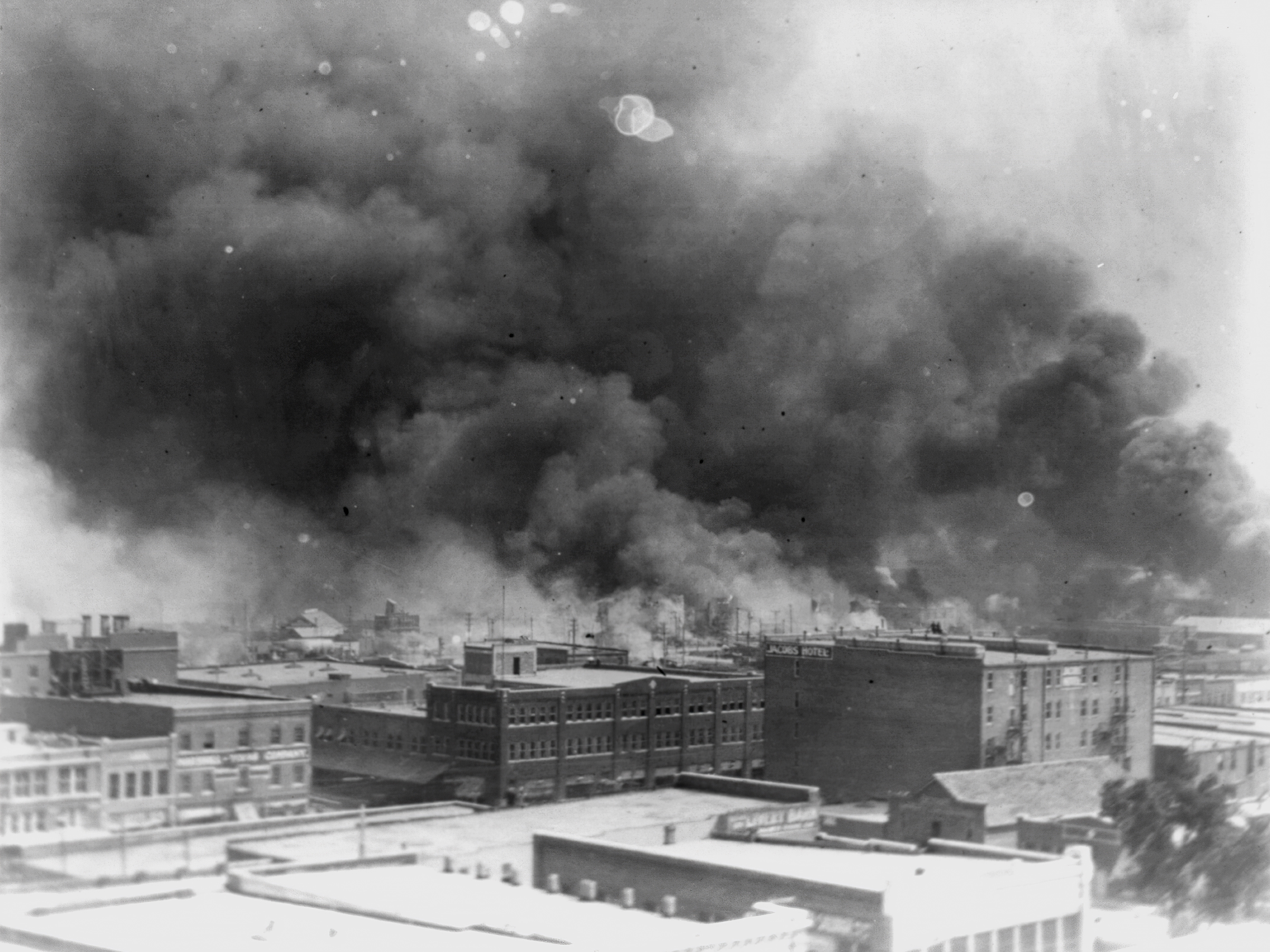 caption: In this 1921 image provided by the Library of Congress, smoke billows over Tulsa, Okla. 