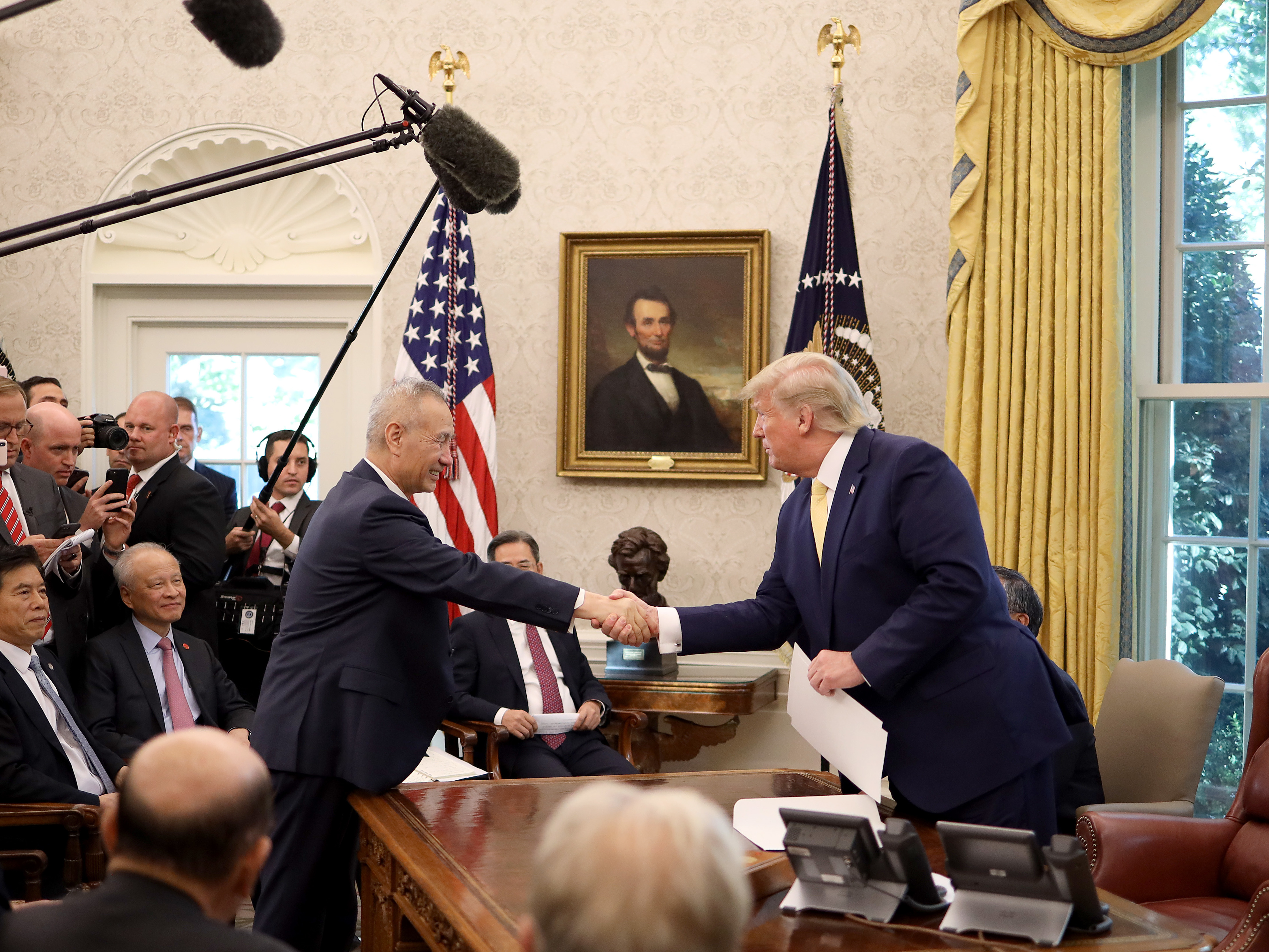 caption: U.S. President Donald Trump shakes hands with Chinese Vice Premier Liu He in the Oval Office at the White House October 11, 2019 in Washington, DC. President Trump announced a 'phase one' partial trade deal with China.
