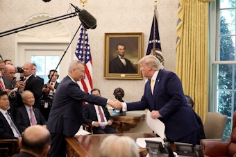 caption: U.S. President Donald Trump shakes hands with Chinese Vice Premier Liu He in the Oval Office at the White House October 11, 2019 in Washington, DC. President Trump announced a 'phase one' partial trade deal with China.