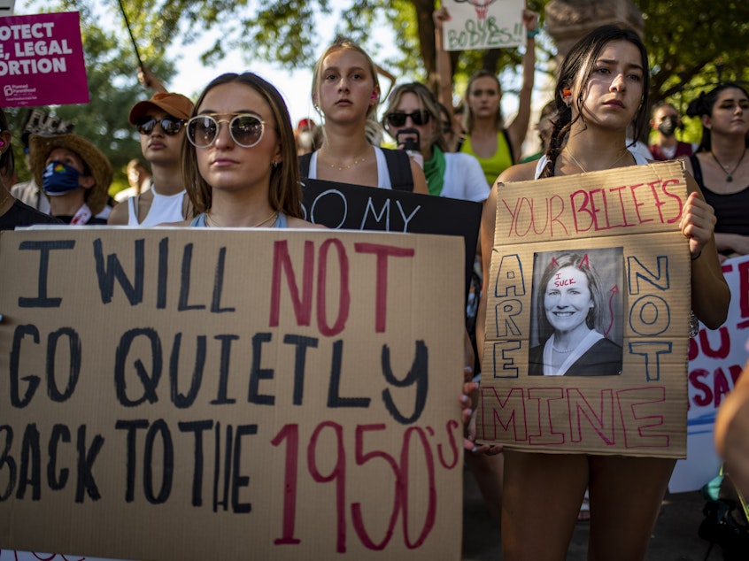 caption: Protesters hold up signs during an abortion-rights rally on Saturday in Austin, Texas.