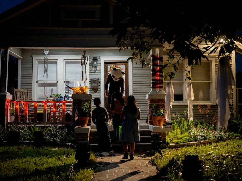 caption: Children go trick-or-treating on Oct. 31, 2022, in Houston.