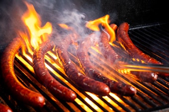 caption: Blake Foraker grills gene-edited German-style sausages at Washington State University.