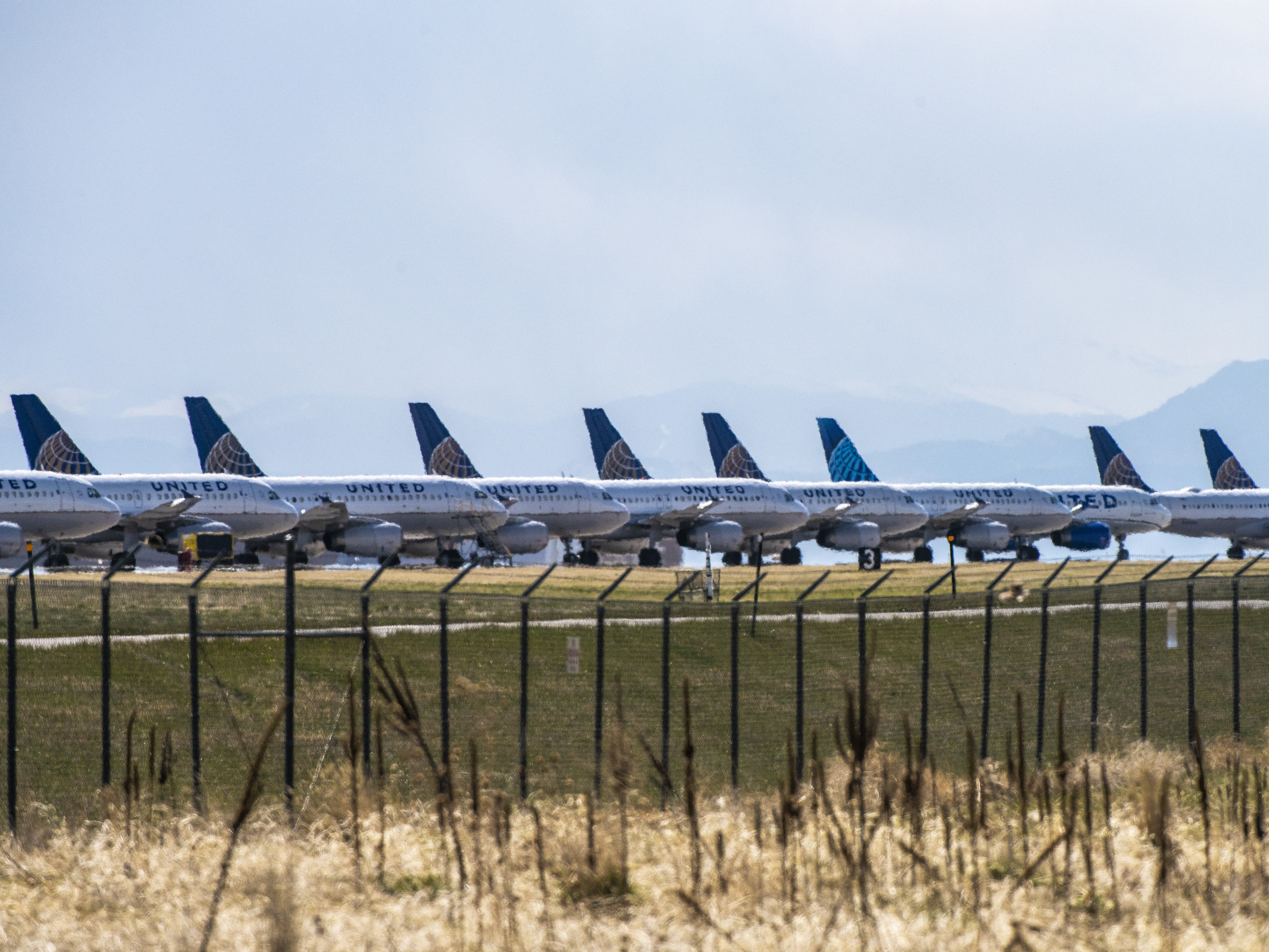 caption: United Airlines planes sit parked on a runway at Denver International Airport on April 22, 2020 as the coronavirus pandemic slows air travel.