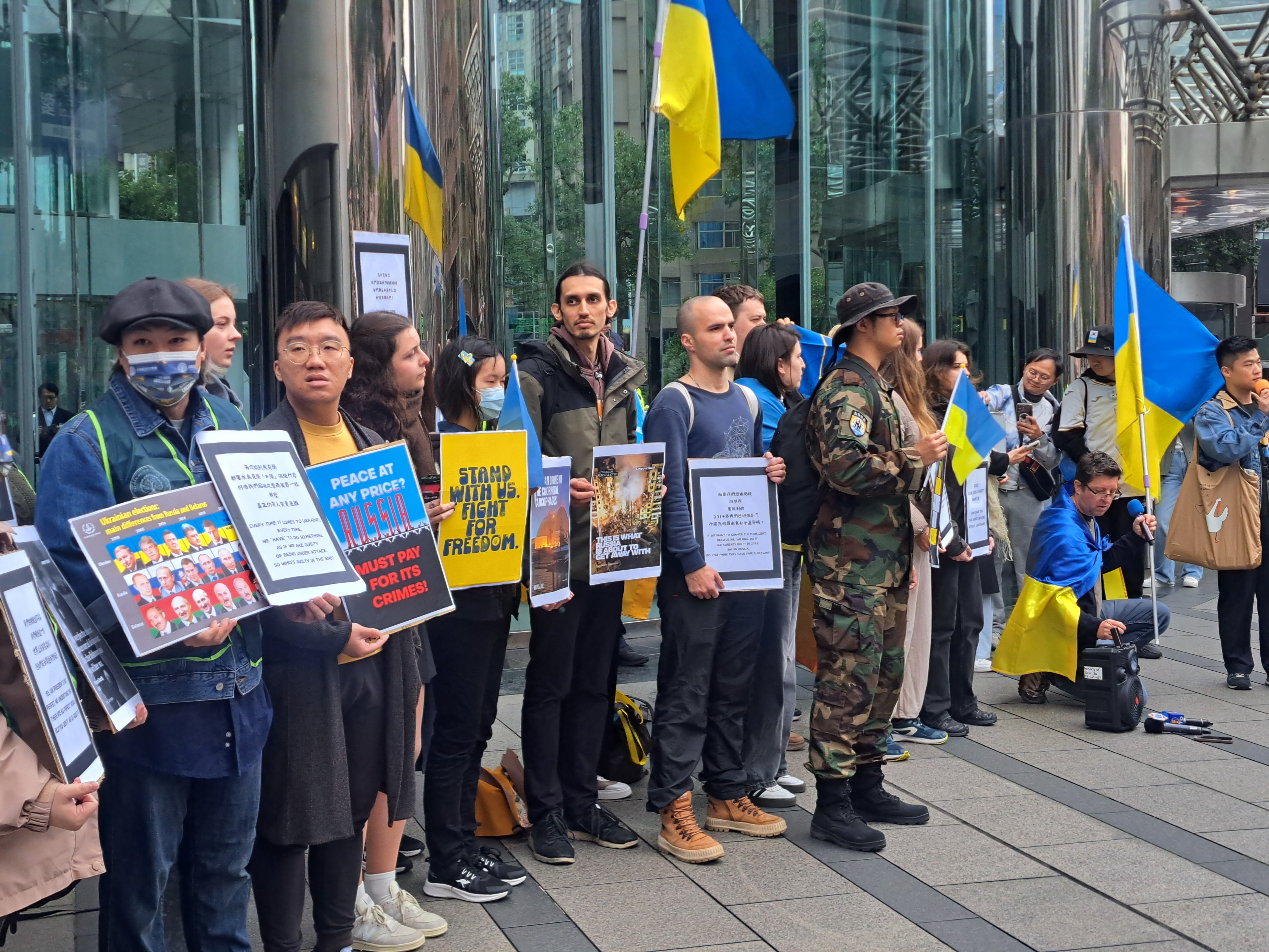 caption: Members of the Ukrainian community in Taiwan, alongside Taiwanese supporters, gather outside Moscow's representative office in Taipei to protest the three-year anniversary of Russia's full-scale invasion of Ukraine