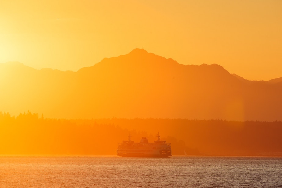caption: The Seattle-Bremerton ferry passes through Elliott Bay under the outline of the Olympics at sunset, September 1, 2021. The Washington State Ferry system has been toting passengers across Seattle waters for the past 70 years. In a normal year, the WSF serves around 24 million riders, that number dropped precipitously to around 10 million in 2020 due to the pandemic.