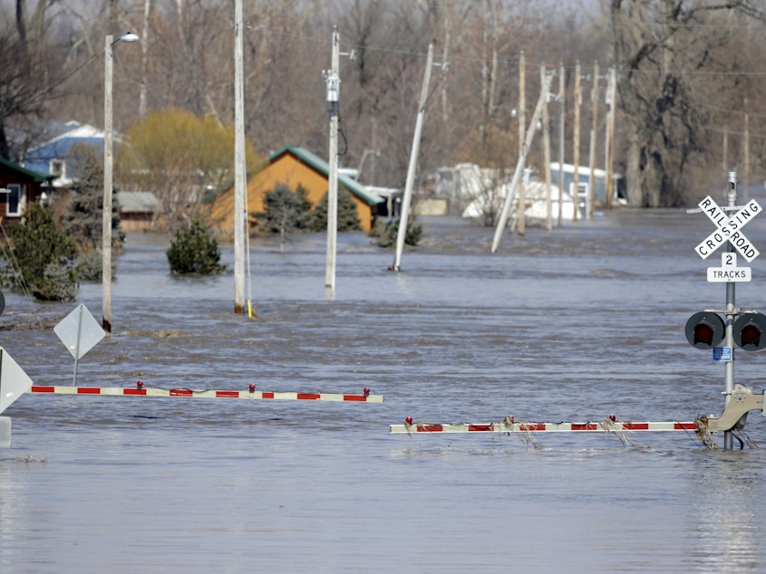 caption: A railroad crossing is flooded with water from the Platte River in Plattsmouth, Neb., after record high floodwaters inundated regions of the Midwest following an intense winter storm and rapid snowmelt.