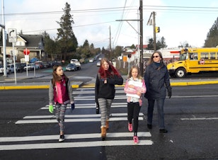 caption: Angel Hackman leads Ruby Oswell (center left) and her friends across Aurora's new crosswalk at 92nd on their way to school.