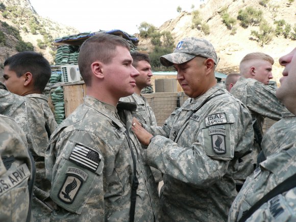 caption: Staff Sgt. Conrad Begaye awards Spc. Kyle White the Combat Infantryman Badge during a ceremony in Nuristan province, Afghanistan, Nov. 6, 2007. The CIB is awarded to Infantry or Special Forces Soldiers who actively engage in ground combat with the enemy.