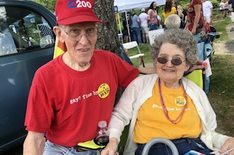 caption: Jerry Miller and his wife, Bea, at the picnic. The couple wears matching T-shirts that read "Gay? Fine by me."