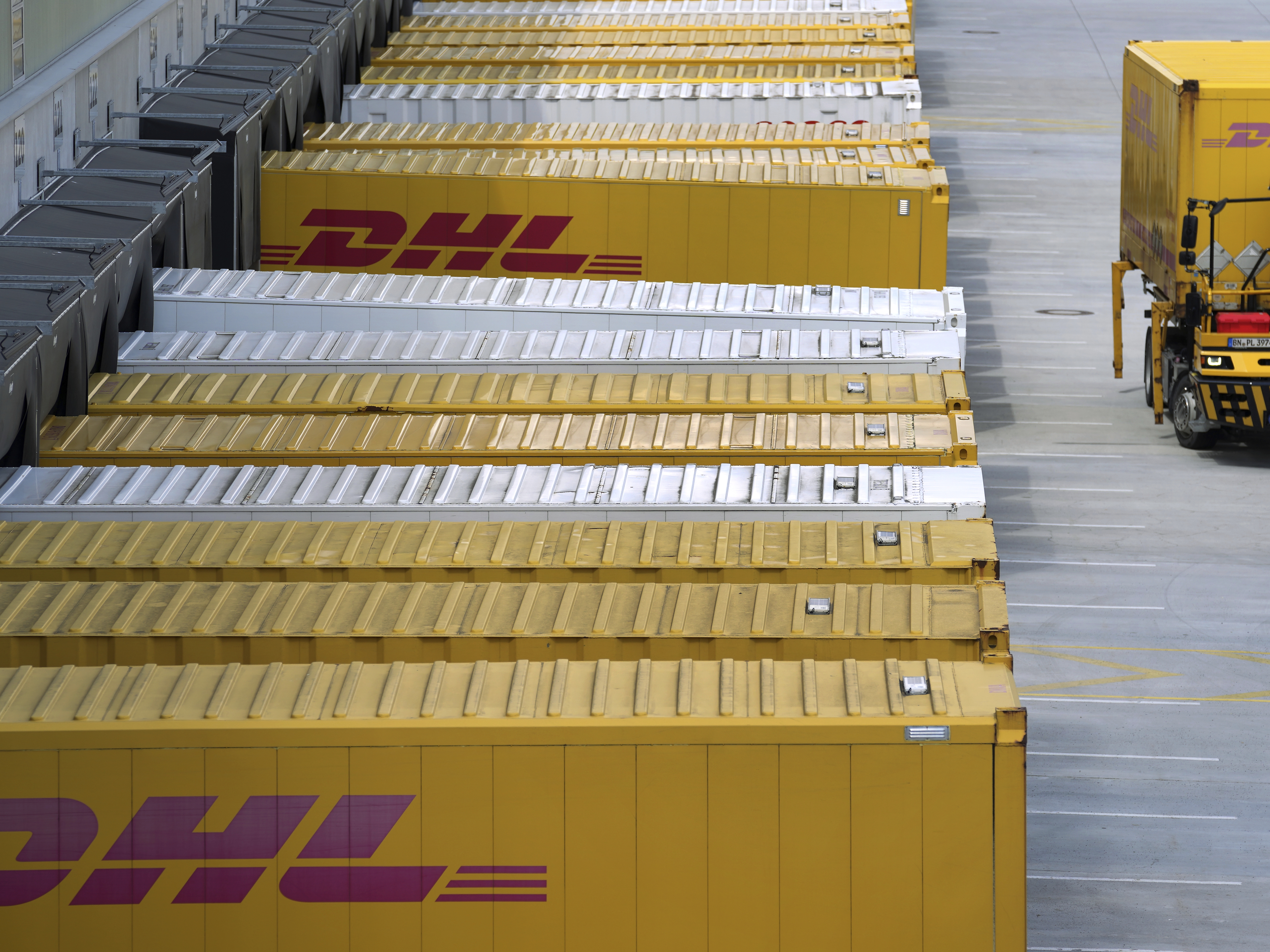 caption: A transfer truck arrives at a DHL facility in Ludwigsfelde near Berlin, Germany, in May 2022. The company said this week it would resume shipping packages valued over $800 to individual U.S. customers.