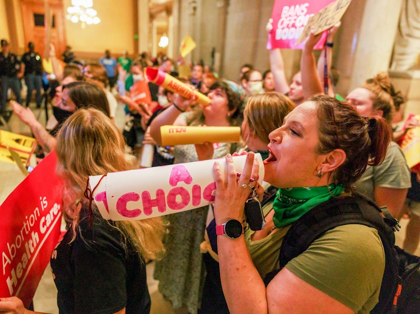 caption: Abortion rights activists chant slogans as the Indiana Senate debates during a special session in Indianapolis before voting to ban abortions.