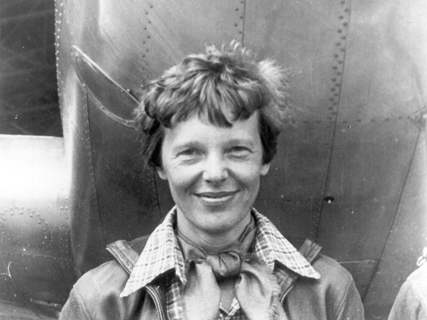 caption: File photo of Amelia Earhart beneath the nose of her Lockheed Model 10 Electra in Oakland, California, in March 1937.