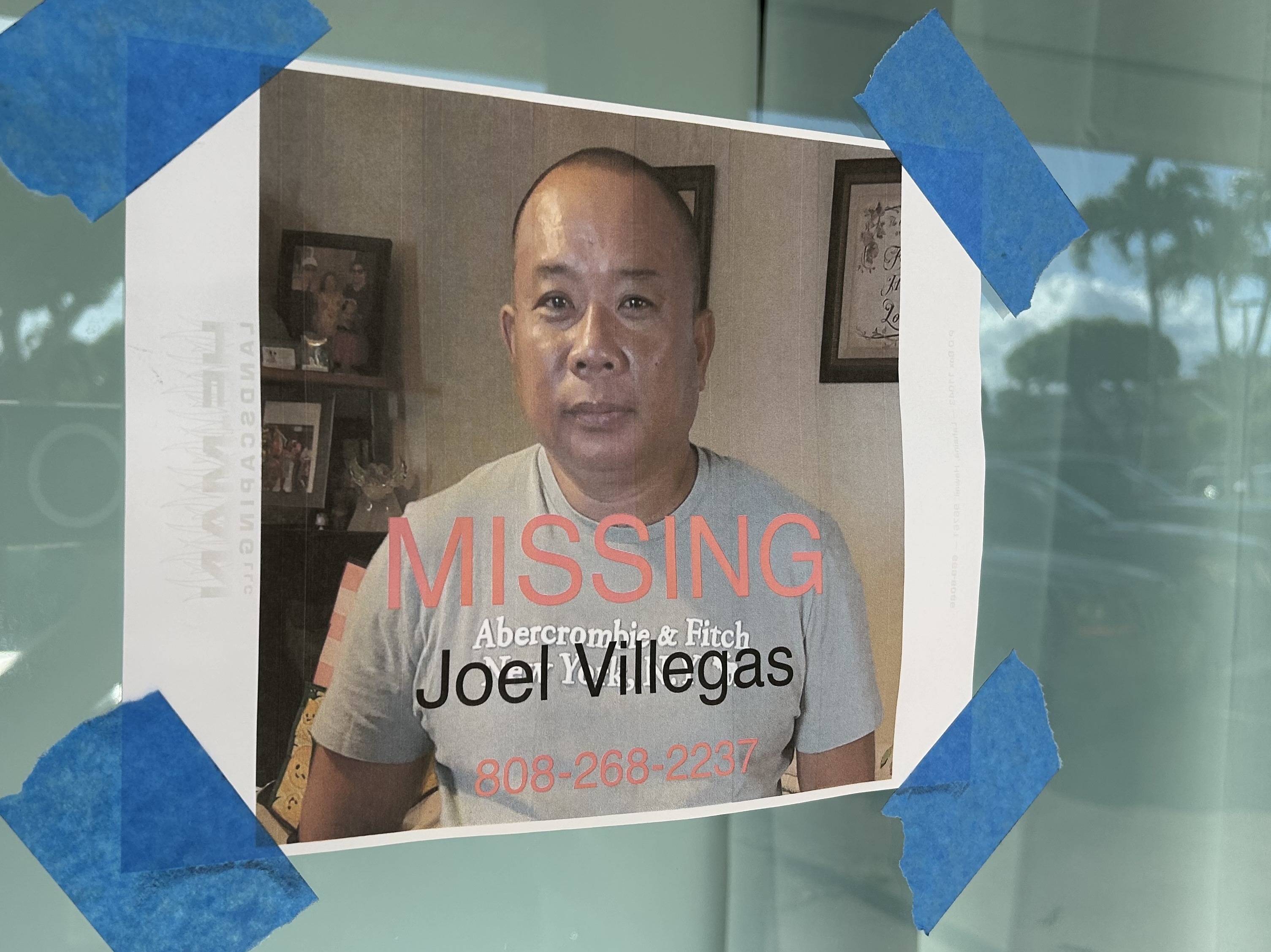 caption: A poster seeking help finding a man not seen after the Lahaina fire is taped to a store window. The official figure of people listed as "not accounted for" has changed drastically this week.