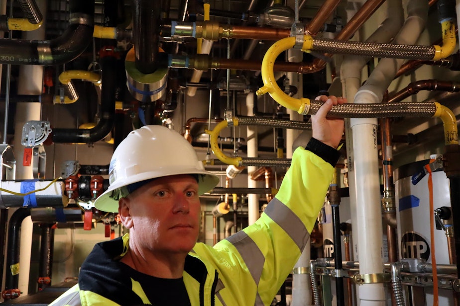 caption: Samaritan North Lincoln Hospital facilities director Chris Lemar shows flexible piping designed to withstand earthquake shaking in the new hospital.