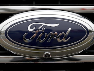 caption: The Ford Bronco logo is displayed on a vehicle in Colma, Calif., on Jan. 5. The American automaker is splitting its auto business into two units.