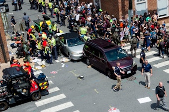 caption: People receive first-aid after a car ran into a crowd of protesters in Charlottesville, Va., on Aug. 12, 2017. Terrorism researchers say right-wing extremists are turning cars into weapons in response to the ongoing protests against police misconduct.