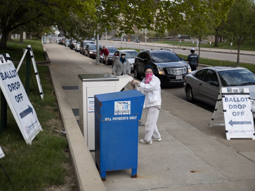 caption: Ohio voters drop off their ballots last month in Dayton. The state's Republican secretary of state has gotten pushback from within his own party for wanting to expand absentee voting during the pandemic.