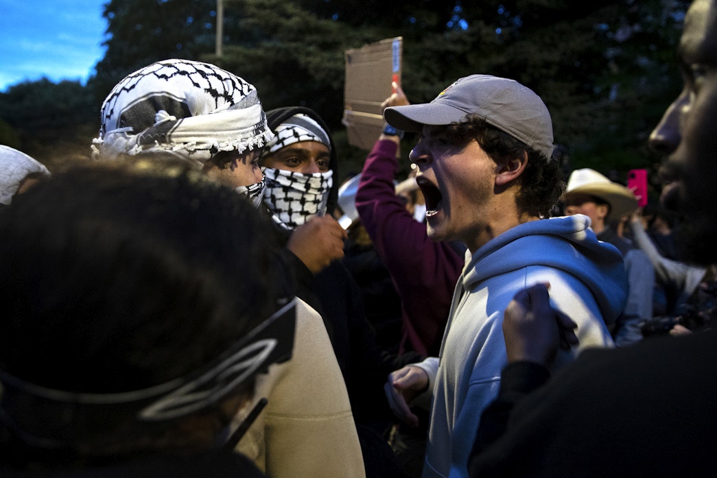 caption: Following a talk by Turning Point USA founder Charlie Kirk, supporters clashed with University of Washington students and protesters who barricaded the east entrance to the encampment for Palestine on the Quad on Tuesday, May 7, 2024, in Seattle. 