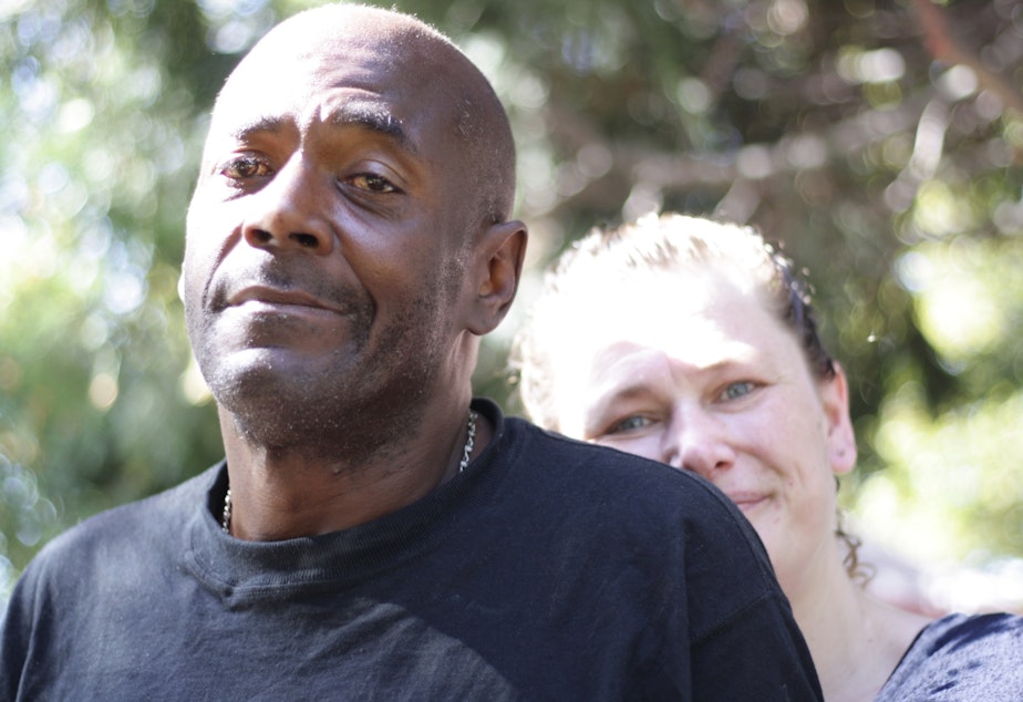 caption: Eric Jordan and Lisa Hooper are trying to make their camp just off Rainier Avenue South more tidy and clean. But they feel constrained by the state, which won't let them bring in garbage cans or porta-potties and regularly promises to evict them.