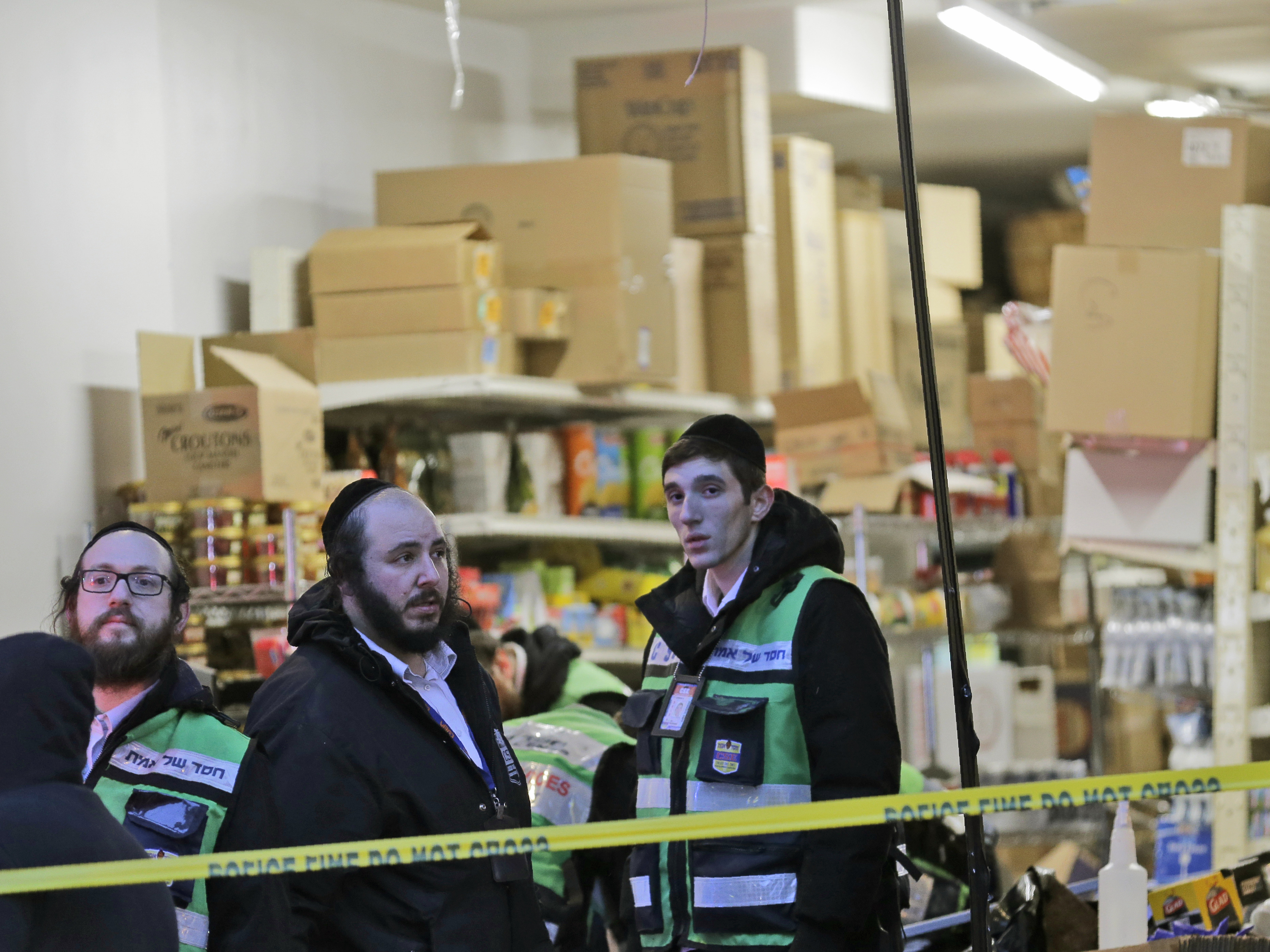 caption: Emergency responders stand Wednesday morning behind police tape outside a kosher supermarket, where a shooting left three people dead one day earlier in Jersey City, N.J. Mayor Steven Fulop said the shooters specifically targeted the market.