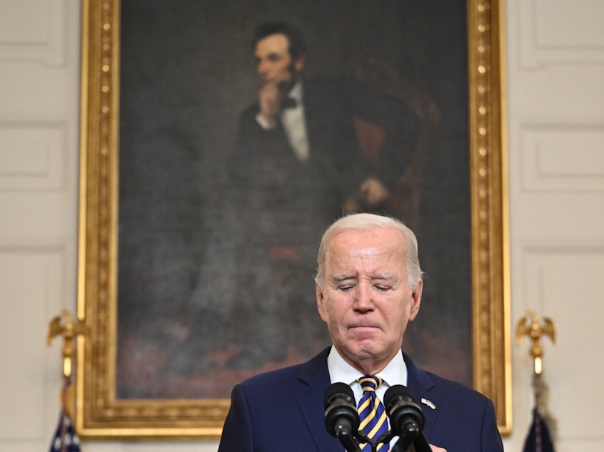 caption: President Biden pauses in remarks in the State Dining Room on Feb. 6. Biden urged Congress to pass a Senate compromise bill with funding for the border, Ukraine and other national security priorities.