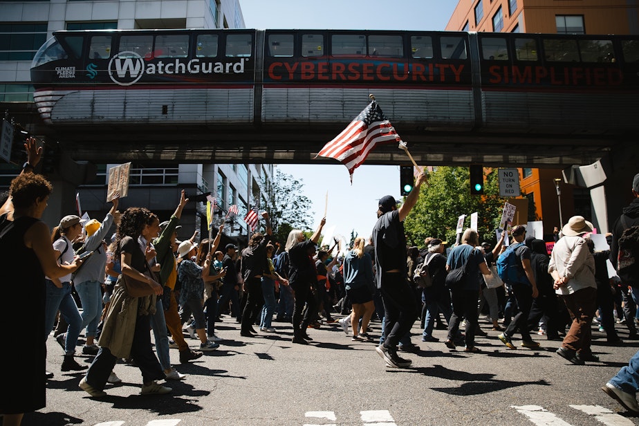 caption: Demonstrators cheer after getting a horn from the Seattle Monorail while marching from Cal Anderson Park to Seattle Center on Saturday, June 14, 2025, during the ‘No Kings’ protest.