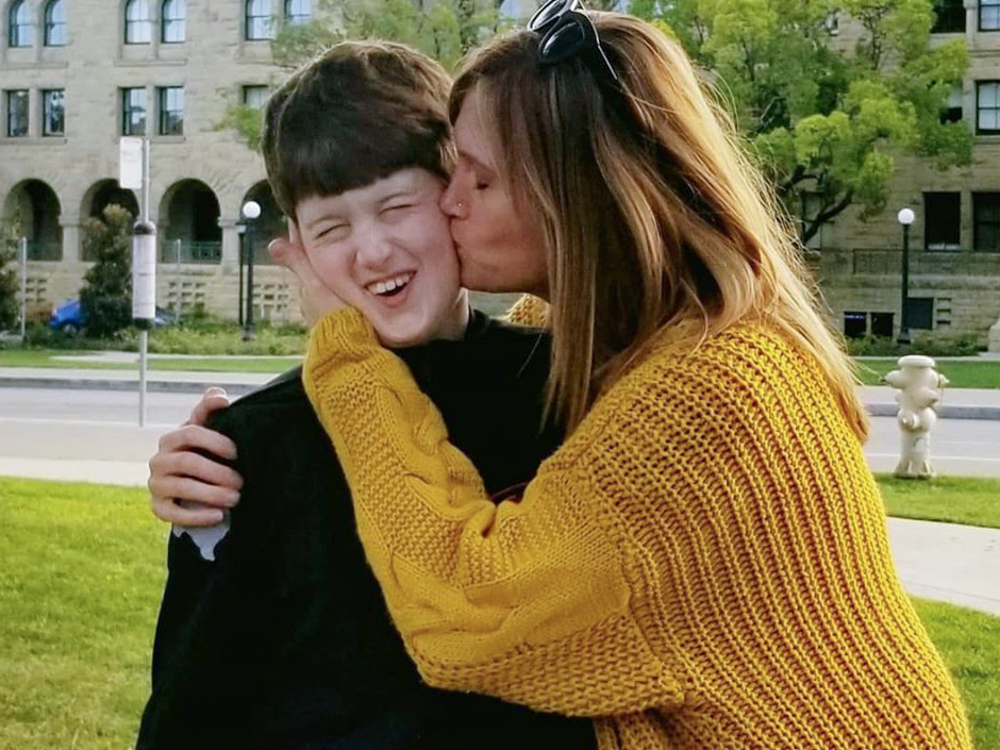 caption: Texas resident Amber Briggle kisses her son. She says the onslaught of anti-trans legislation in the state is emotionally traumatizing.