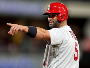 caption: Albert Pujols of the St. Louis Cardinals points to the San Diego Padres dugout after hitting a single during the ninth inning of Monday night's game in San Diego. He ended the night with two singles, a walk and no home runs.