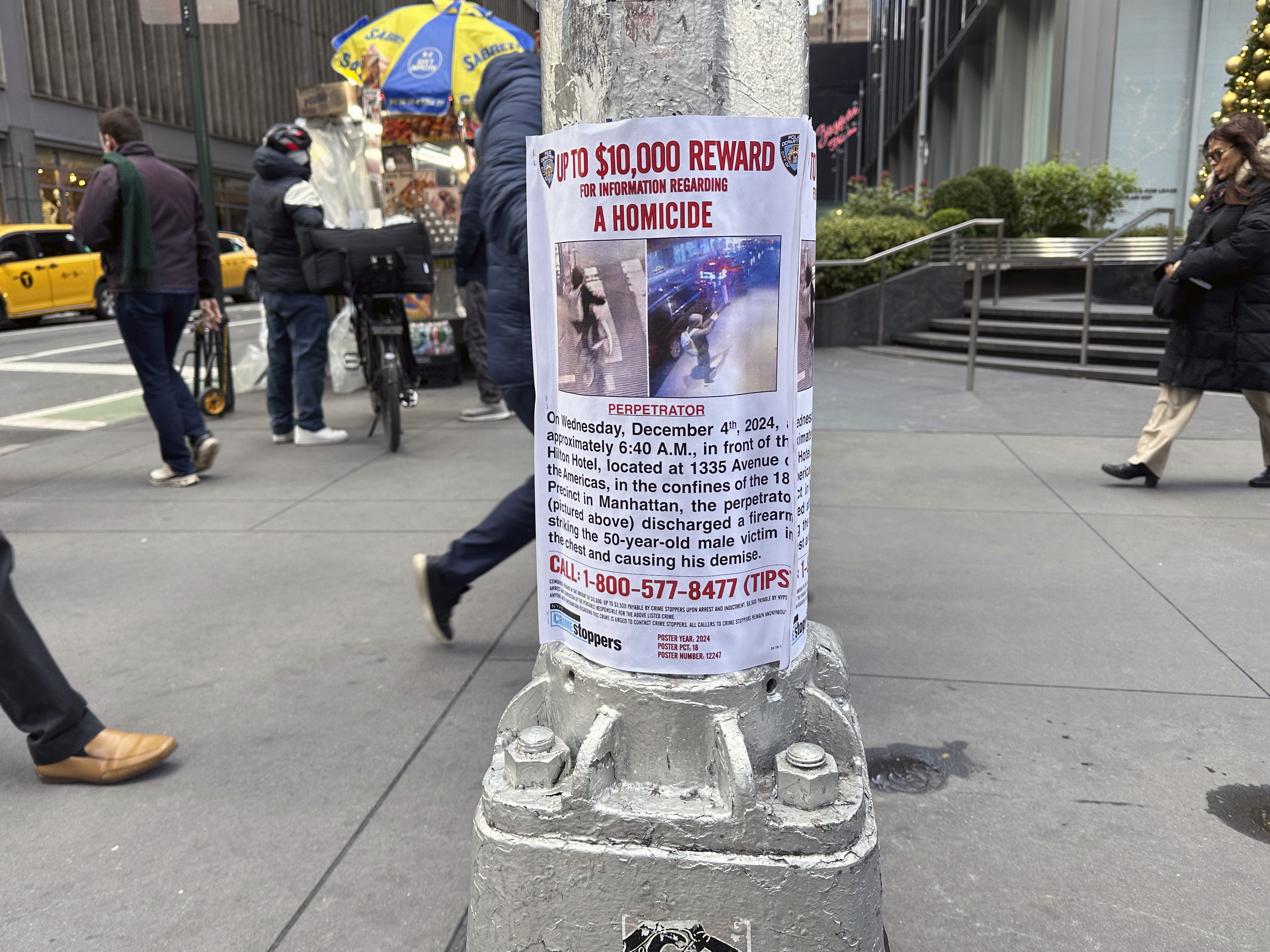 caption: A reward poster hangs on a light pole outside the New York Hilton Midtown Hotel in New York last week. The NYPD offered up to $10,000 for tips leading to the shooting suspect's arrest, while the FBI offered up to $50,000.
