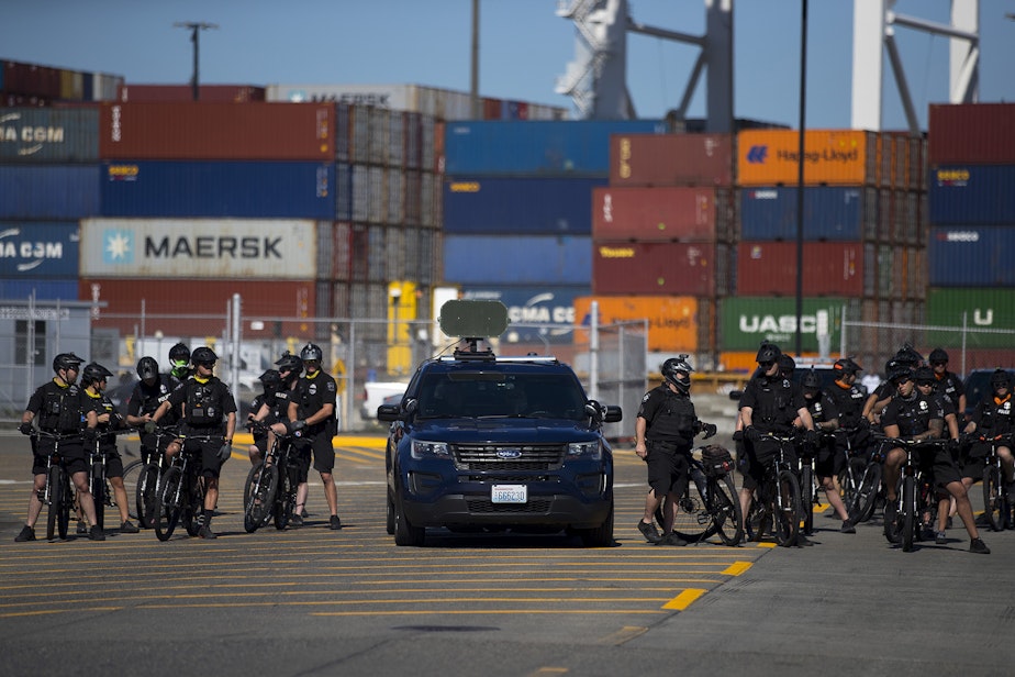 caption: Seattle police officers are shown shortly before giving dispersal orders to activists and allies of the Palestinian feminist organization Falastiniyat, who blocked an intersection in protest of the Israeli Zim San Diego Vessel, on Thursday, June 17, 2021, at the Port of Seattle.