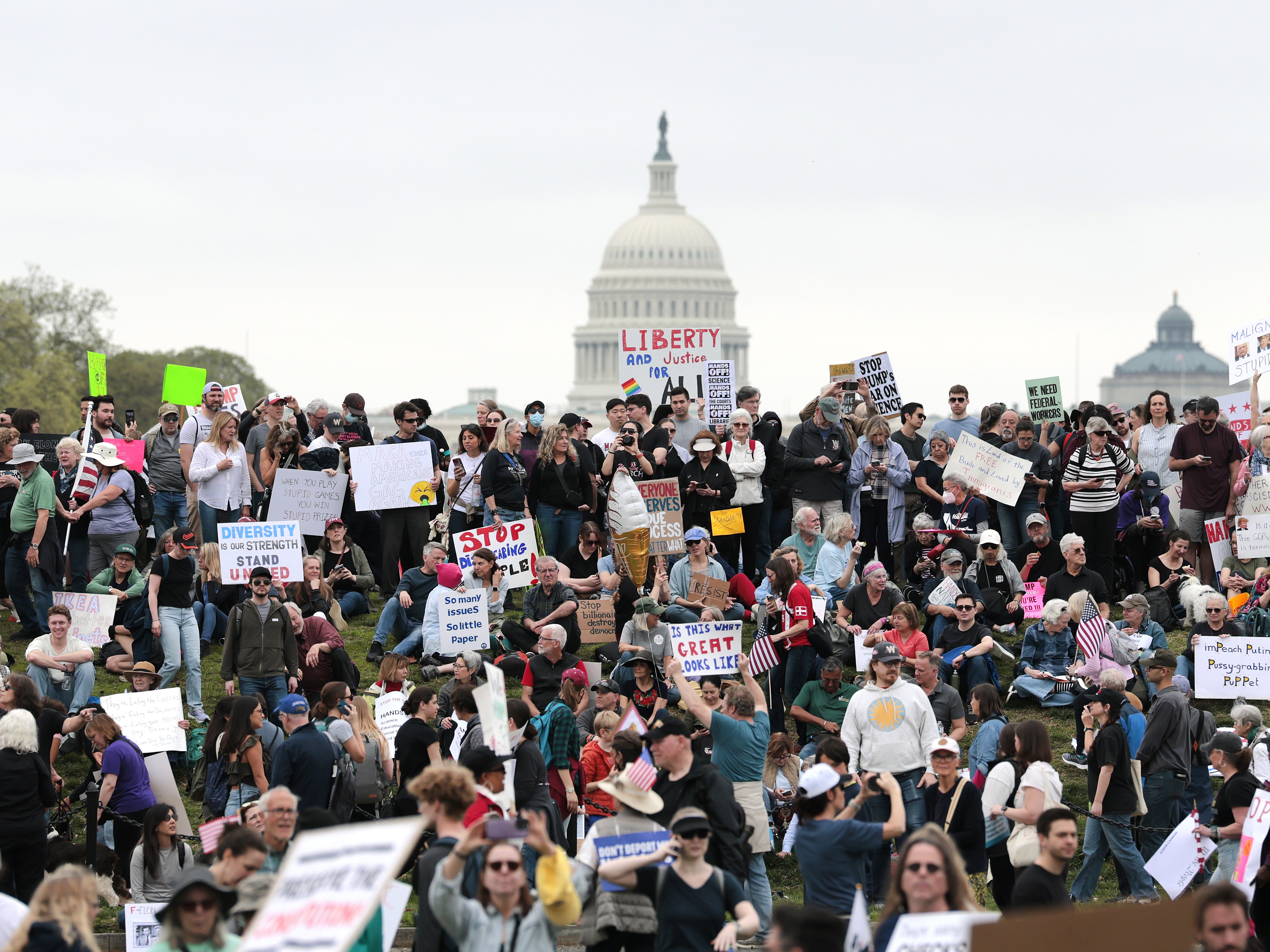 caption: Protesters attend a "Hands Off" rally Saturday to demonstrate against President Trump on the National Mall in Washington, D.C.