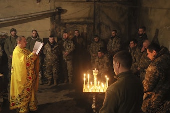caption: A clergyman with the Orthodox Church of Ukraine, Chaplain Ivan, conducts a liturgy for Ukrainian troops near the front line in the eastern town of Vuhledar on Dec. 15.