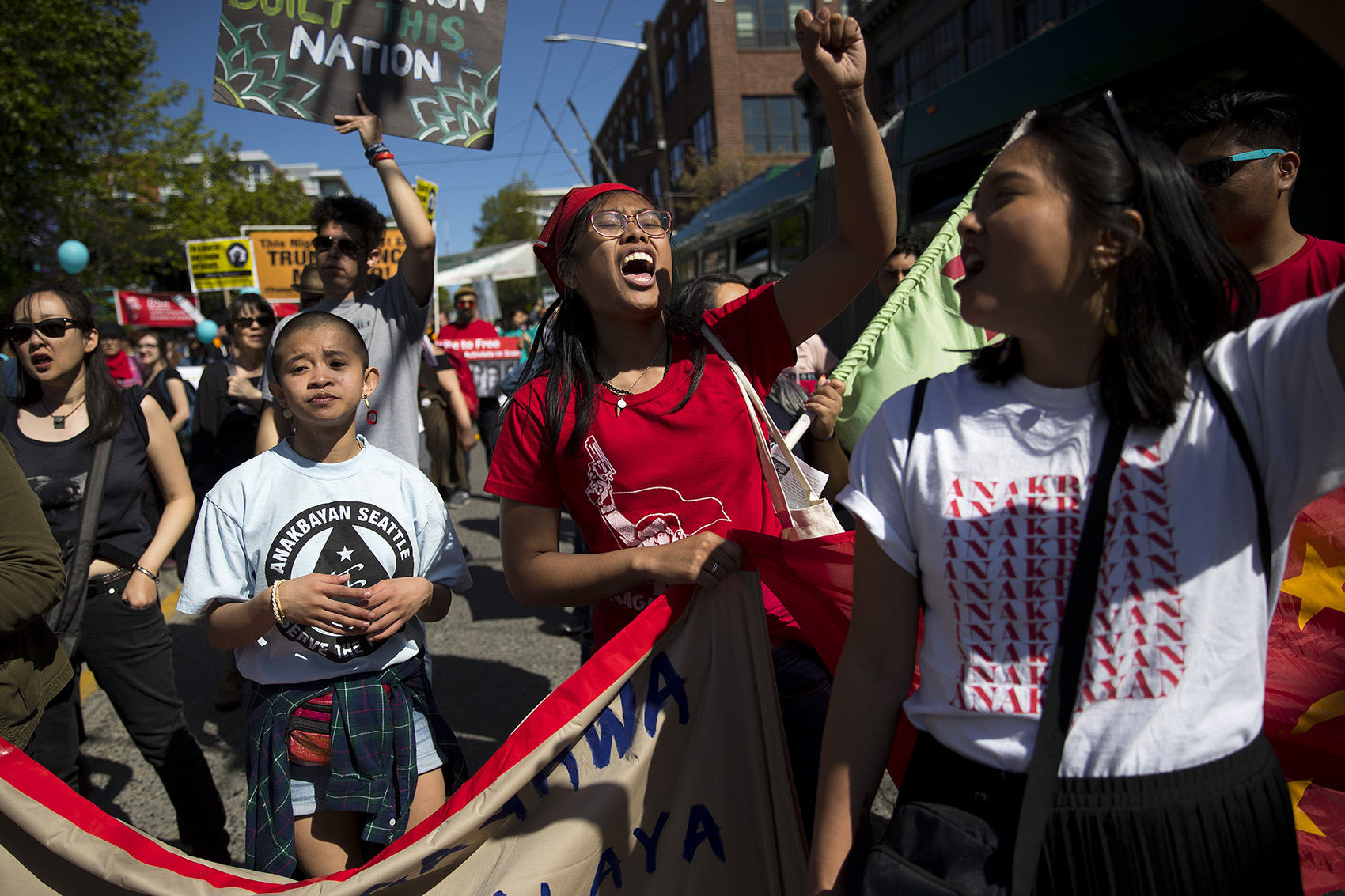 caption: Laurie Rocello Torres, center, with Migrante Seattle, chants while marching on Wednesday, May 1, 2019, during the 20th annual May Day march in Seattle.