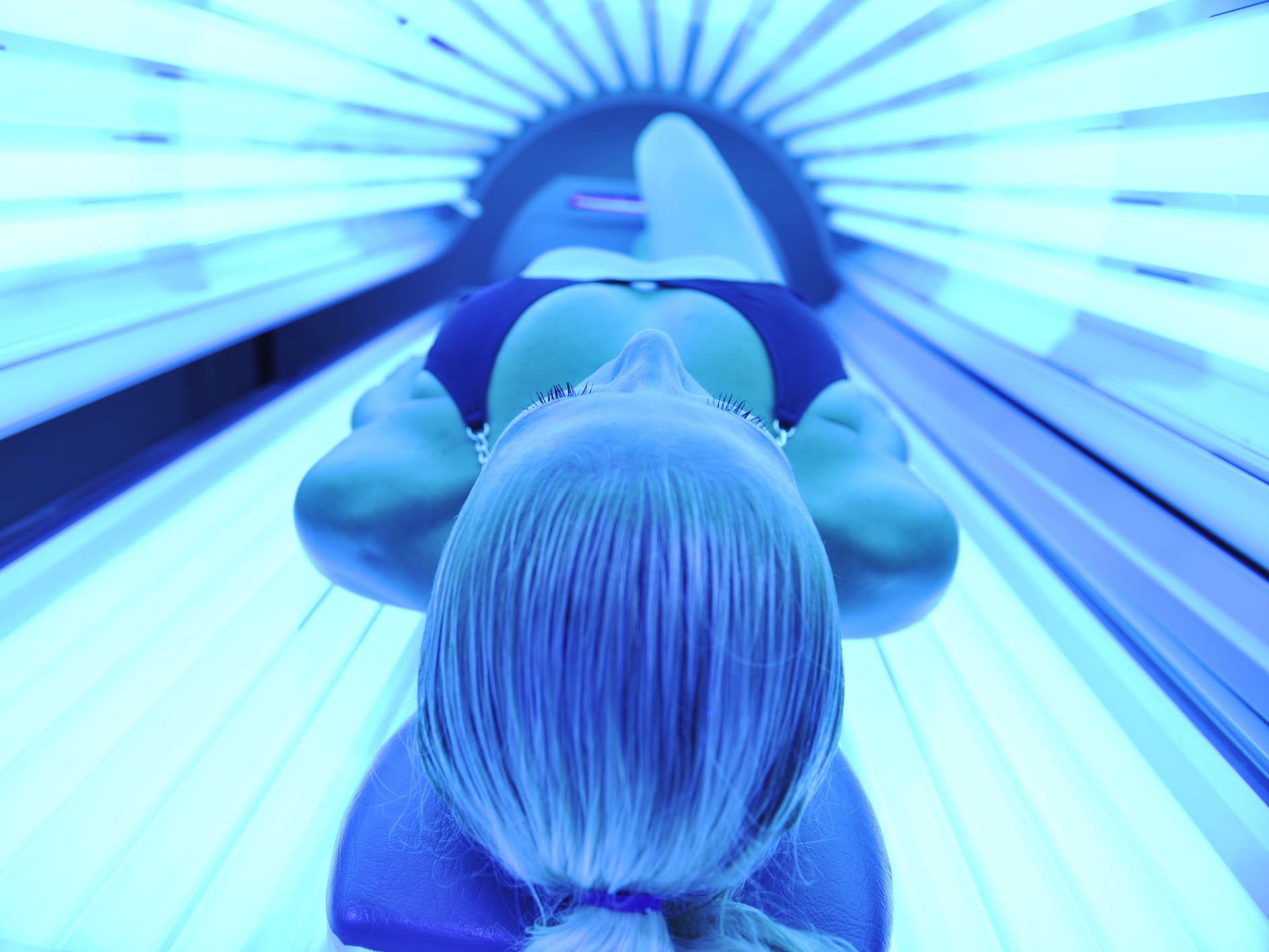 caption: People who regularly use tanning beds are more likely to have DNA damage that can lead to melanoma across nearly the entire surface of their skin.