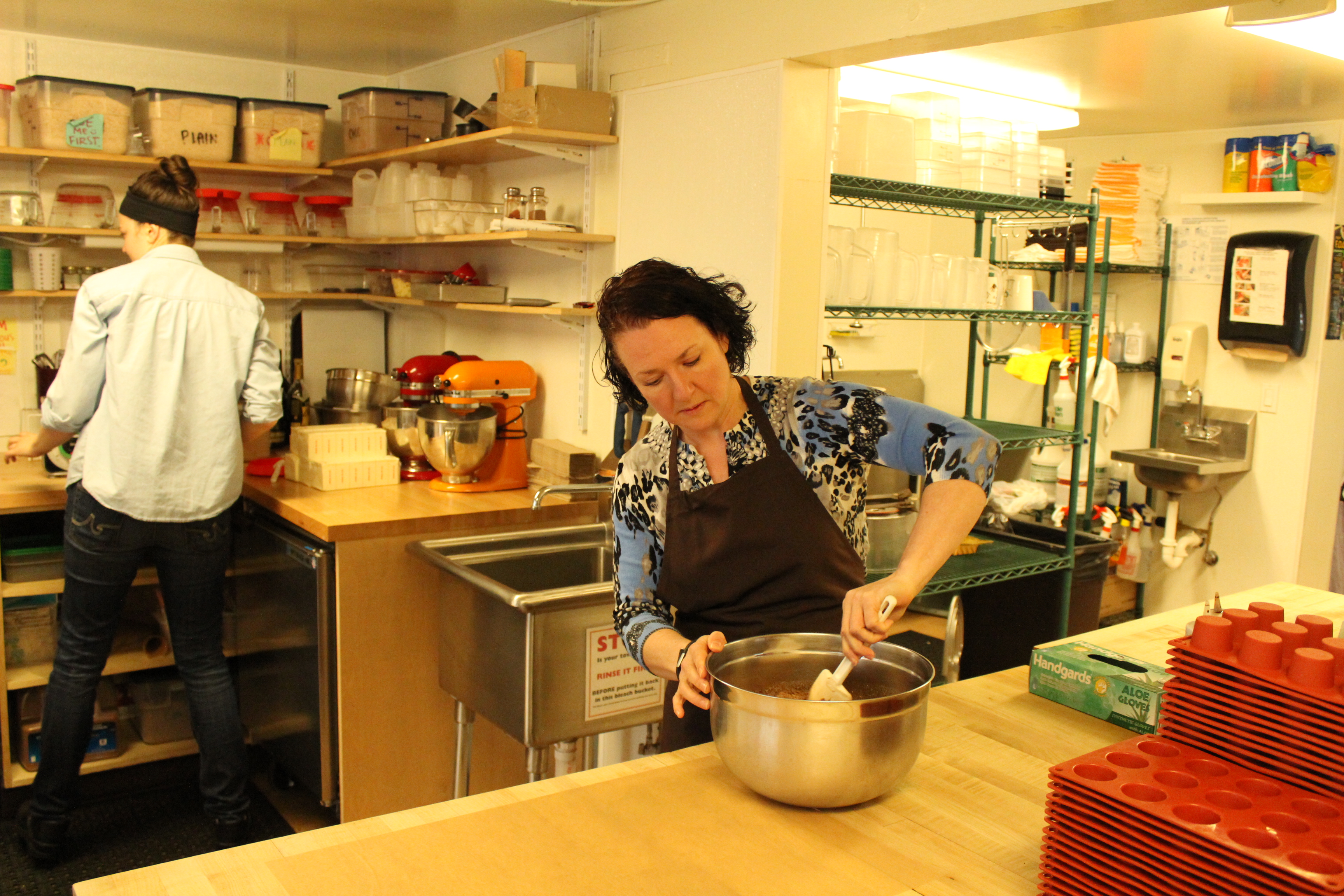 caption: Destiny Sund, co-owner of The Confectional, steps in to help with mixing a crust with baker Heather Hodge.