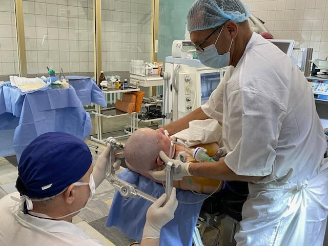 caption: Dr. Andriy Sirko (left), the head of of neurosurgery at Mechnikov Hospital in Dnipro, Ukraine, treats a patient along with Dr. Rocco Armonda, a visiting U.S. neurosurgeon. The hospital is just 60 miles from the frontline of the Russia-Ukraine war and handles the most serious brain injuries.