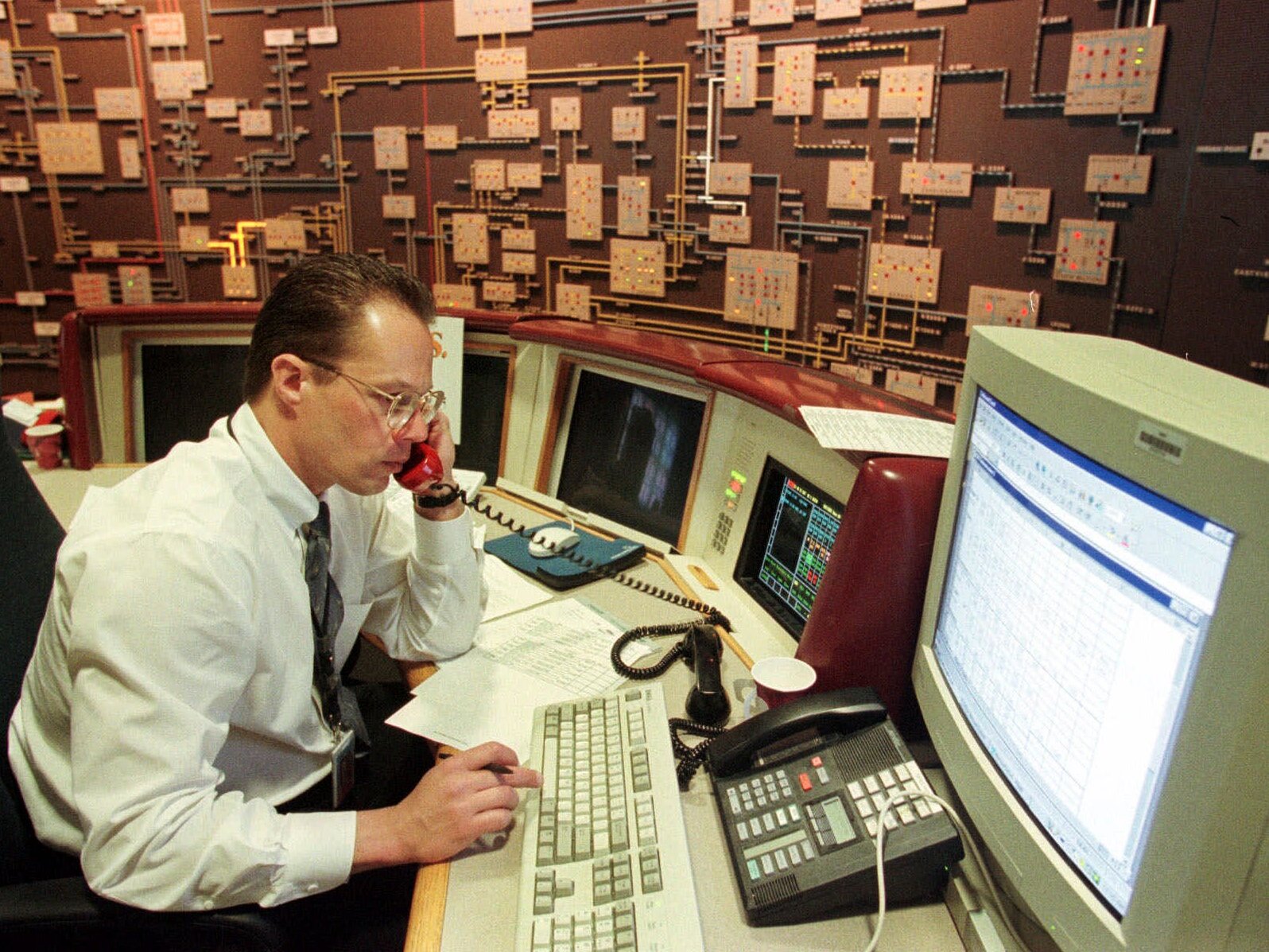 caption: Mike Cupo, a systems operator for Public Service Electric and Gas Company, uses a special red phone to talk via radio to PSE&amp;G staffers in the field, during a simulated Y2K drill at company headquarters in Newark, N.J., on April 9, 1999. Power plant operators across the country held drills to make sure they could keep electricity flowing if year 2000 computer glitches prevented them from communicating with each other.