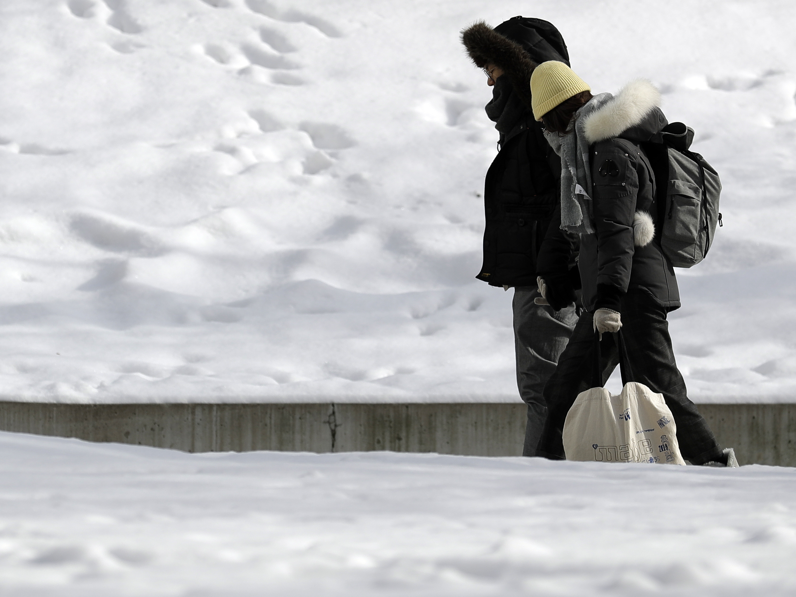 caption: People bundled up against the cold in downtown Chicago on Sunday. Forecasters warned of dangerous weather conditions across a swath of the U.S. over the next several days.