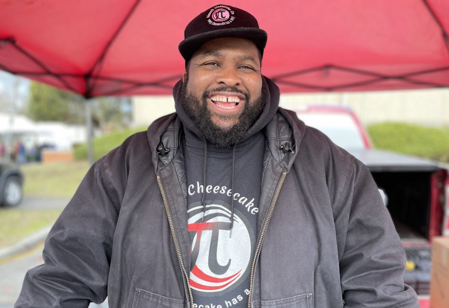 caption: Michael Mason, who goes by "Chef Mason" selling cheesecake and talking community at the Proctor Farmers Market in Tacoma