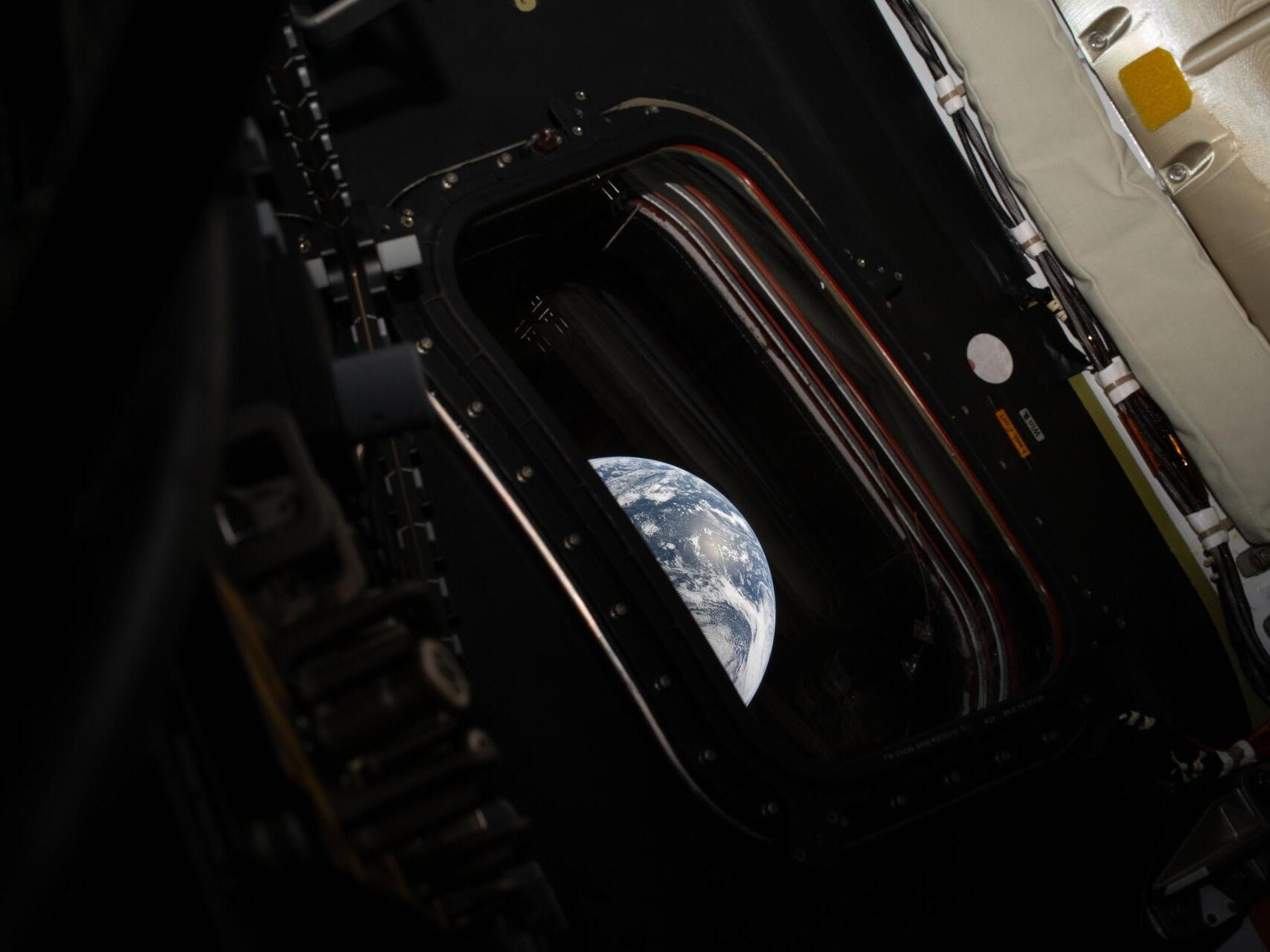 caption: A view of Earth taken by NASA astronaut and Artemis II commander Reid Wiseman from the Orion spacecraft's window after completing the translunar injection burn on April 2, 2026. NASA's Artemis II mission will take Wiseman, Glover, Koch, and Hansen on a 10-day journey around the Moon and back aboard their Orion spacecraft.